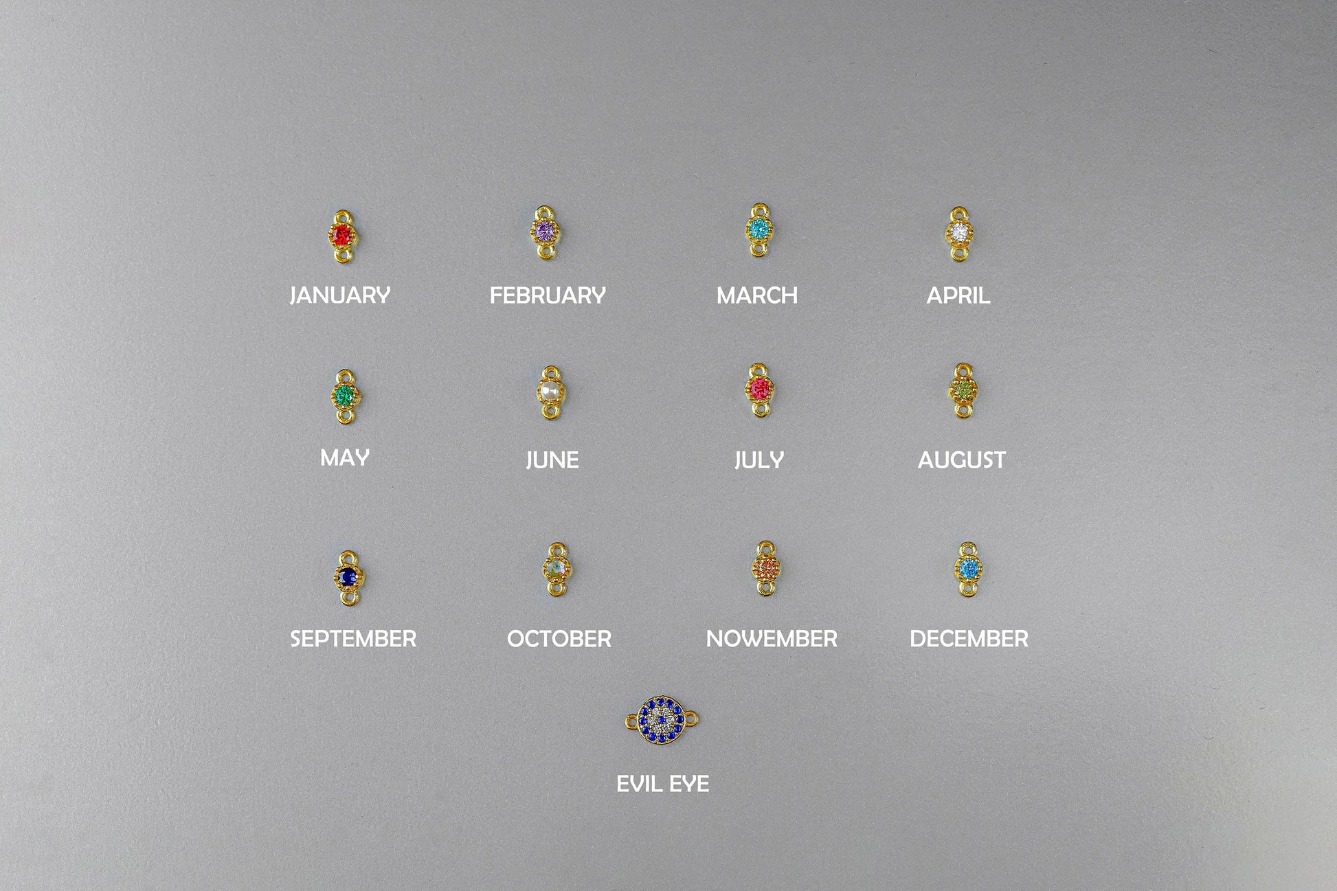 Set of earrings with gemstones for each month on a gray background