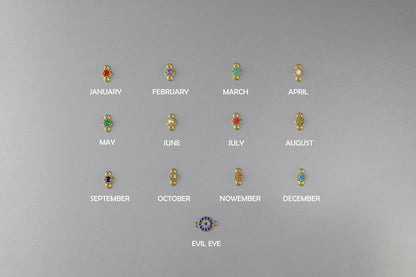 Set of earrings with gemstones for each month on a gray background