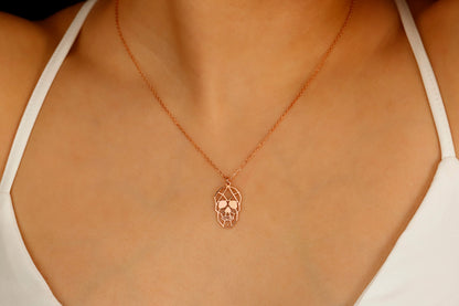 A close-up image of a person wearing a sterling rose necklace with a sugar skull pendant.