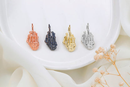 Four variations of a 3D skeleton middle finger sign necklace in different finishes (oxidized, silver, gold, rose gold) displayed on a white surface.