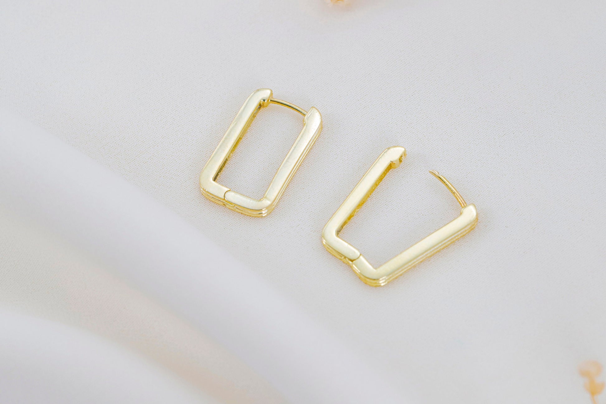 Gold hoop earrings on a light gray background