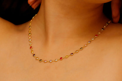A multicolor baguette cut gemstone necklace with a silver finish, displayed on a person's neck.