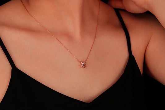 A close-up image of a person wearing a 3D spider necklace made of 925 sterling silver.