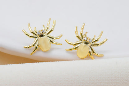 A close-up image of a person wearing a 3D spider stud earring made of gold-filled or sterling silver.