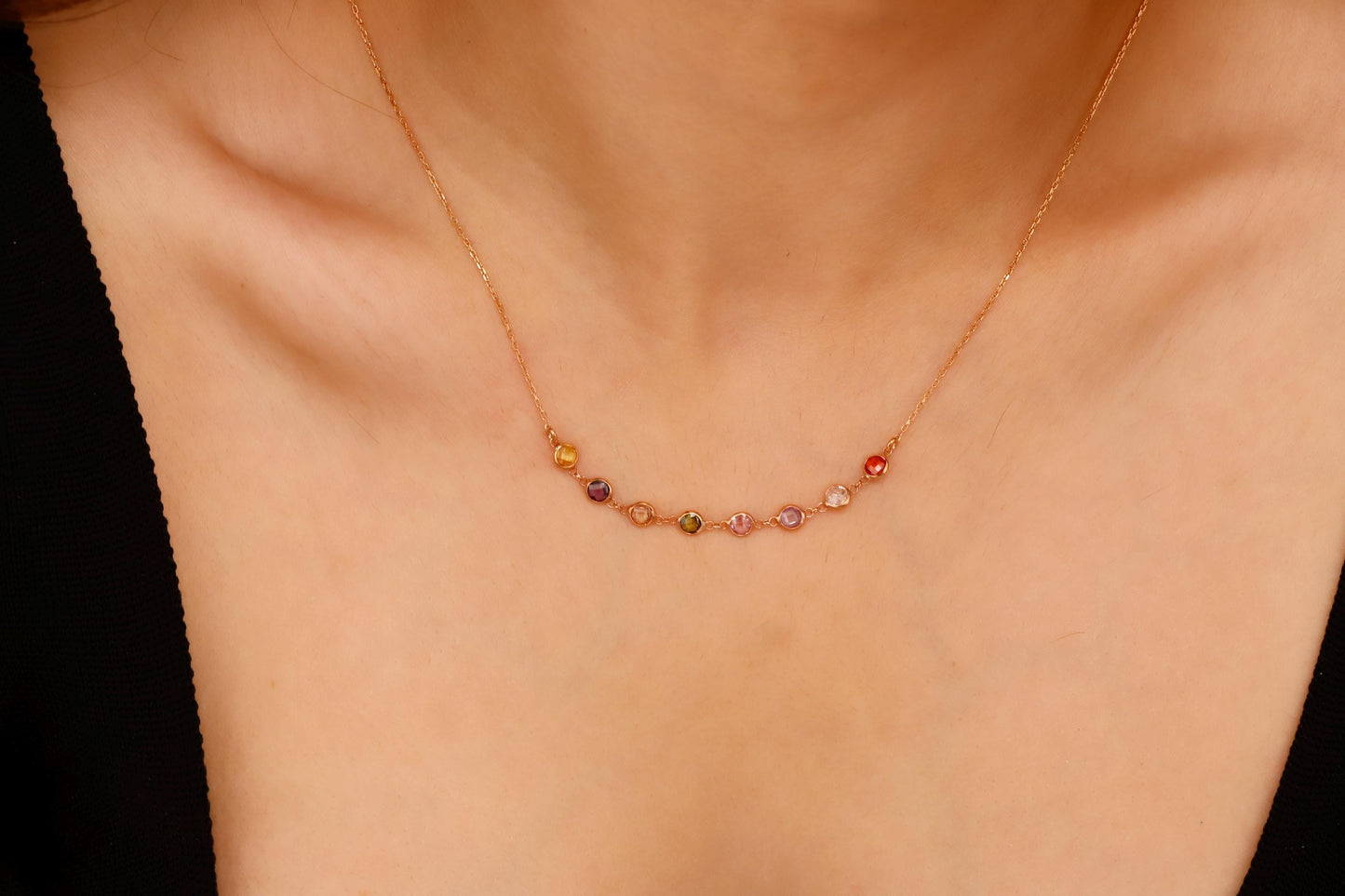 Necklace with multicolored beads on a person's neck against a neutral background