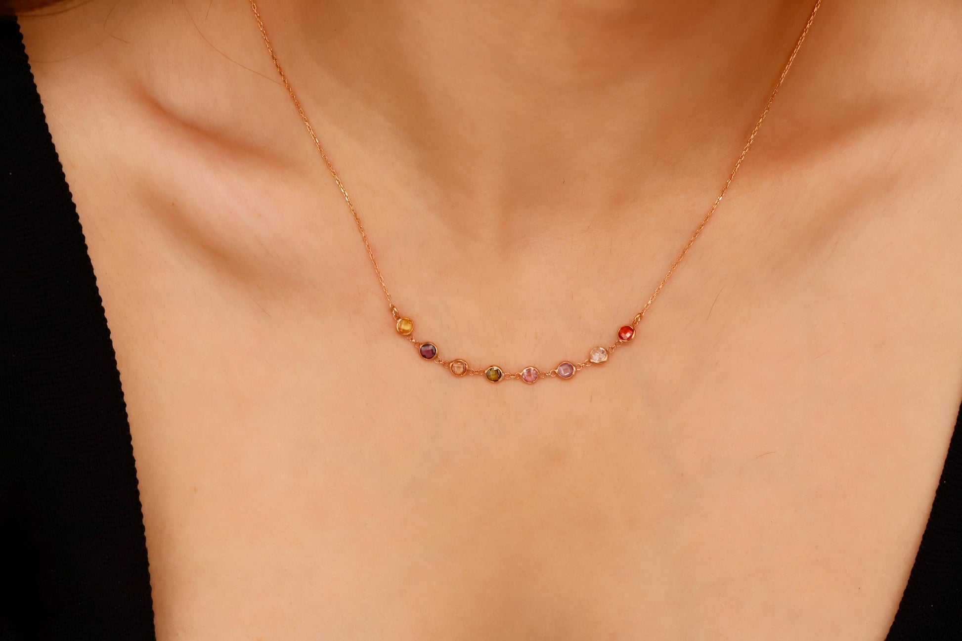 Necklace with multicolored beads on a person's neck against a neutral background