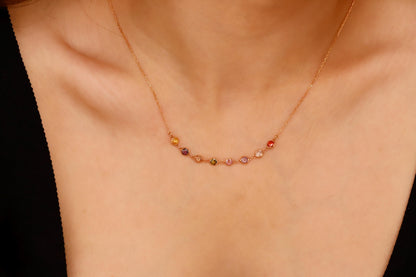 Necklace with multicolored beads on a person's neck against a neutral background