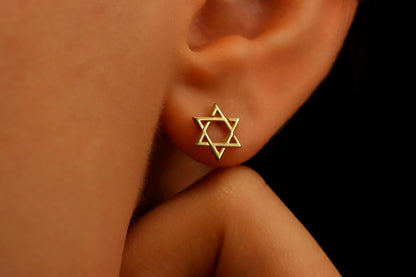 Close-up image of a person wearing a gold-filled David Star earring.