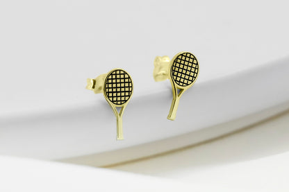A close-up image of a  gold-colored tennis racket stud earring.