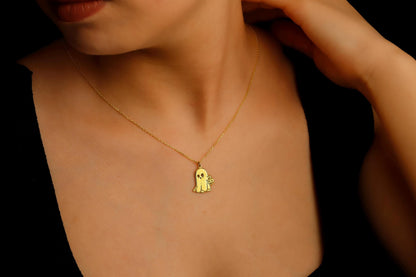 Gold necklace with a small pendant on a person wearing a black top.