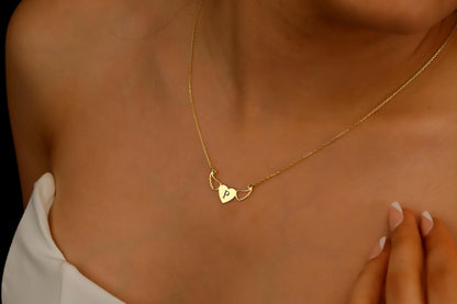 Gold necklace with a heart-shaped pendant on a person's neck