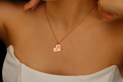 Rose gold necklace with a heart-shaped pendant worn by a person