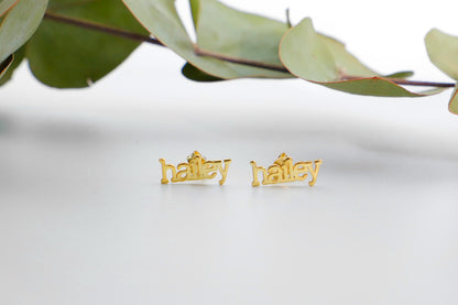  a pair of gold name earrings with the name 'hailey' inscribed on them.