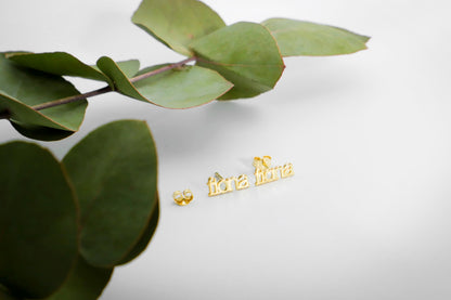 a pair of gold name earrings with the name 'fiona' inscribed on them.