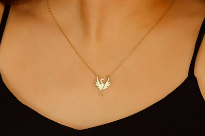 Gold necklace with a unique pendant on a person wearing a black top.