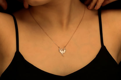 Necklace with a small pendant worn by a person in a black top.
