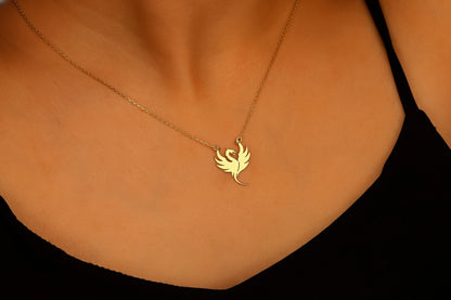 Gold necklace with a bird-shaped pendant on a person's neck