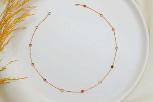 Delicate necklace with small beads on a white plate with a natural background
