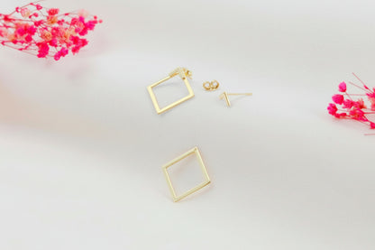 Gold square ear jacket earrings on a light background with pink flowers