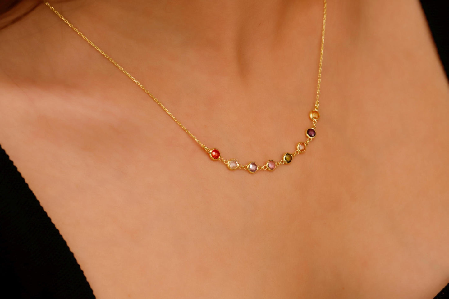 Gold necklace with colored beads on a person's neck