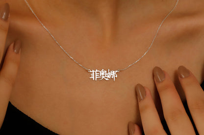A close-up image of a woman wearing an 18K gold filled pendant necklace with Chinese characters.