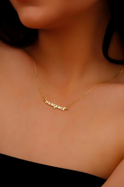 Gold necklace with 'marqueta' pendant on a person's neck