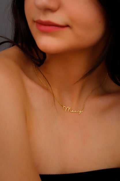 A gold name necklace with the name 'Merry' displayed on a model.