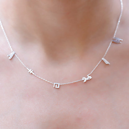 A sterling silver necklace with hieroglyphic characters customized on a person's neck.