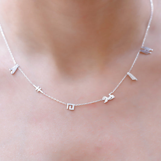 A sterling silver necklace with hieroglyphic characters customized on a person's neck.