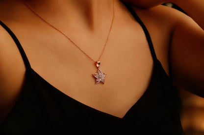 A gold-filled necklace with a lily flower pendant, worn by a person.