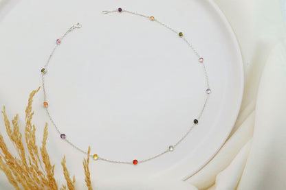 Necklace with colorful beads on a white plate with a soft background
