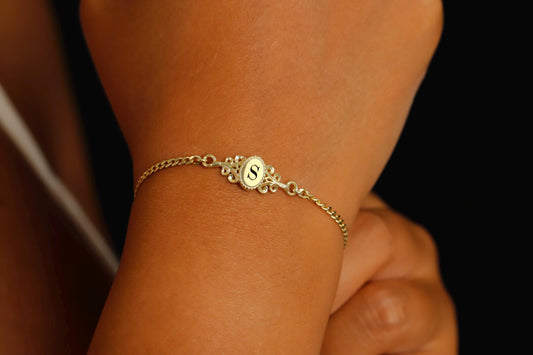 a custom vintage style bracelets in gold, with an engraved letter.