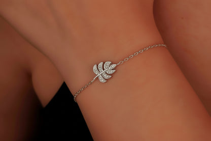 Silver leaf bracelet on a wrist with a blurred background