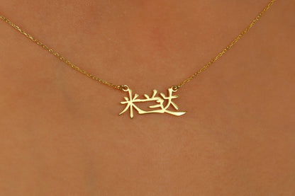 A close-up image of a woman wearing an 18K gold filled pendant necklace with Chinese characters.