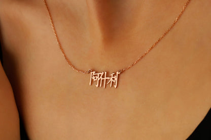 A close-up image of a woman wearing an 18K rose gold filled pendant necklace with Chinese characters.