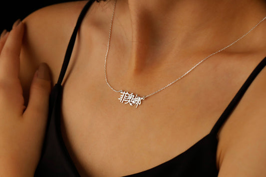 A close-up image of a woman wearing an 18K gold filled pendant necklace with Chinese characters.