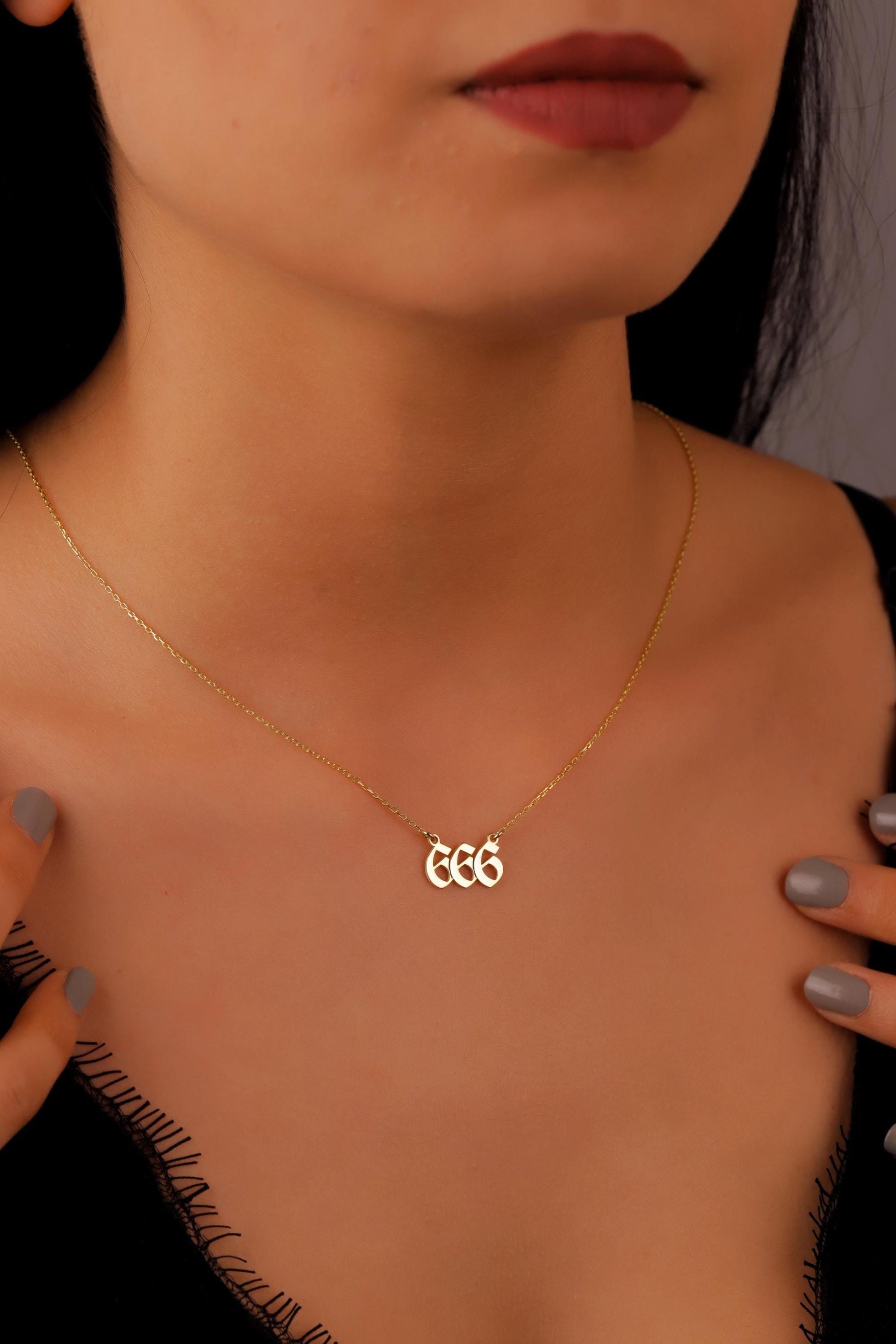 Gold necklace with initials worn by a person