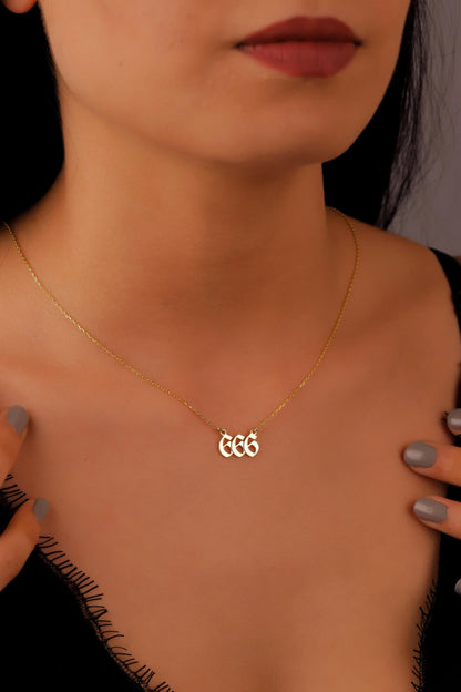 Gold necklace with initials worn by a person