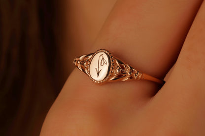 Rose gold ring with intricate design on a finger