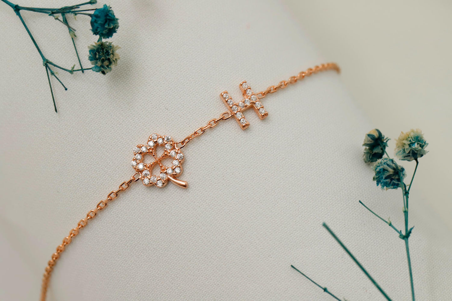 Rose gold bracelet with floral design on a light background with dried flowers