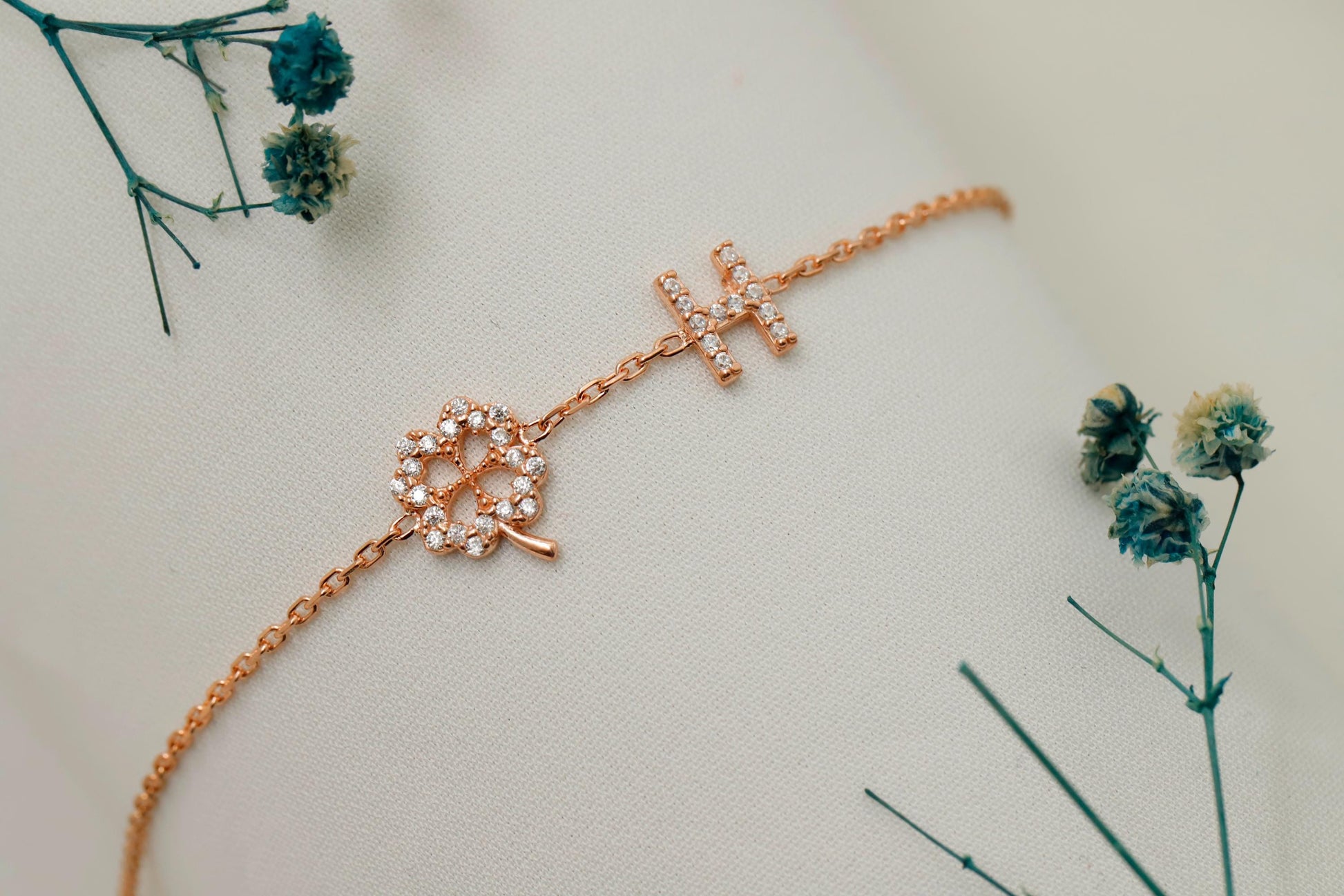 Rose gold bracelet with floral design on a light background with dried flowers