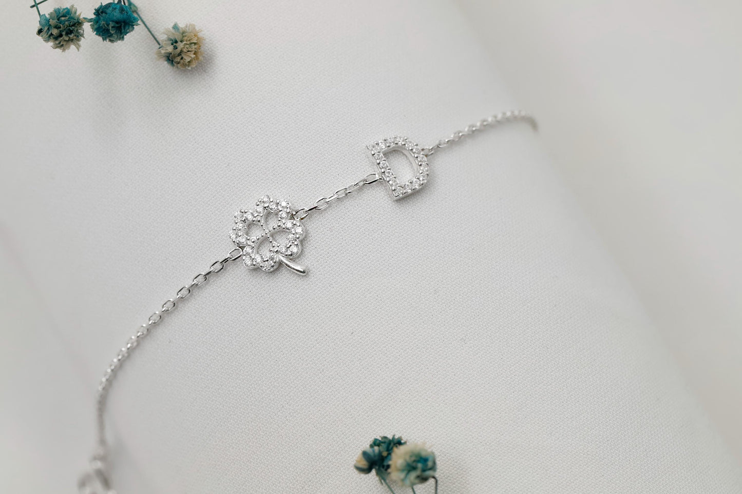 Silver bracelet with floral design on a light gray background