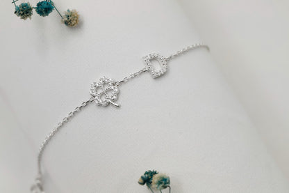 Silver bracelet with floral design on a light gray background