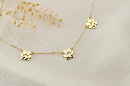 A close-up image of a gold-filled paw-shaped necklace with a custom animal name pendant.