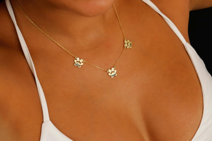 A close-up image of a person wearing a gold-filled paw-shaped necklace with a custom animal name pendant.