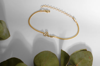 A close-up image of  a personalized name bracelet with a chain link design in silver.