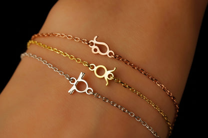 Three gold and silver bracelets on a wrist against a dark background