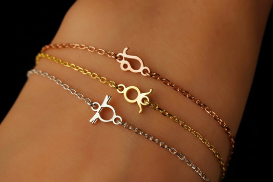 Three gold and silver bracelets on a wrist against a dark background
