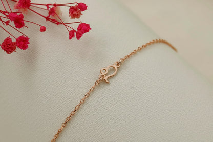 Rose gold bracelet on a light background with red flowers