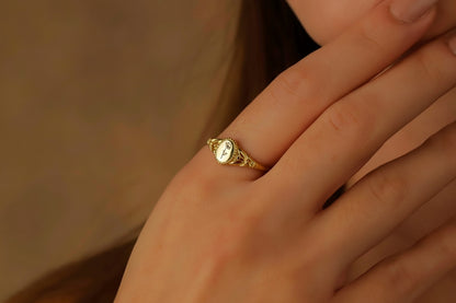 Gold ring on a person's finger with a blurred background